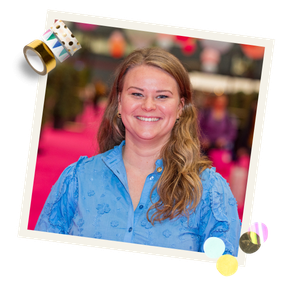 Portret van lachende vrouw in blauwe blouse, roze beursvloer op achtergrond, fotoframe met tape en stippen